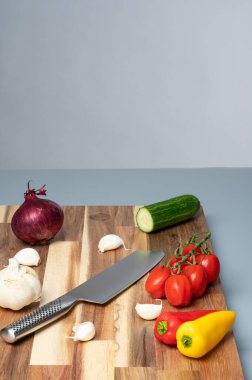 Çizgili ahşap kesme tahtasına yerleştirilmiş çeşitli taze sebzelerin tepeden tırnağa görüntüsü. Tarifler, yemek planlaması, yemek blogları ve fotokopi alanı olan yemek tasarımı için temiz mutfak hazırlık geçmişi.