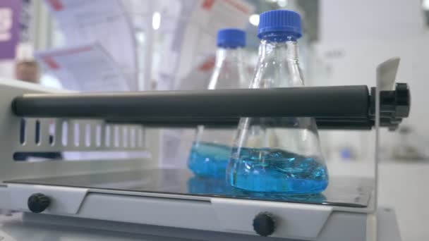 Moderne Labors entwickeln neue Medikamente. Glaskolben rotieren im Labor. Wissenschaftler entwickeln eine neue toxische Substanz. Medizinische Tests. Mischen blauer Flüssigkeit in Laborgläsern — Stockvideo