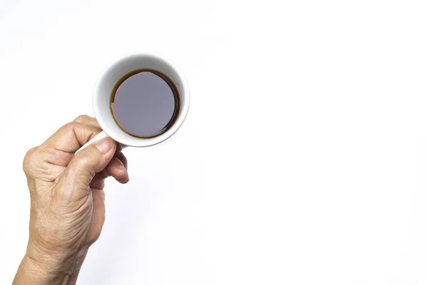 Mano izquierda de la mujer mayor sosteniendo taza de café negro aislado sobre fondo blanco —  Fotos de Stock