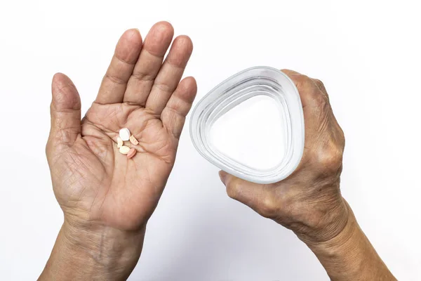 Руки Пожилой Женщины Таблетками Треугольным Стаканом Воды Здравоохранение Медицинская Концепция — стоковое фото