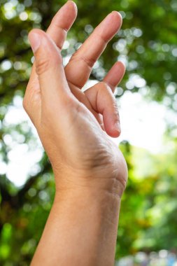 Kadın yan Sol el halka parmak tetik parmak kilidi, ağrı muzdarip, bokeh yeşil bahçe arka plan, yakın çekim & makro Shot, ofis sendromu, sağlık kavramı
