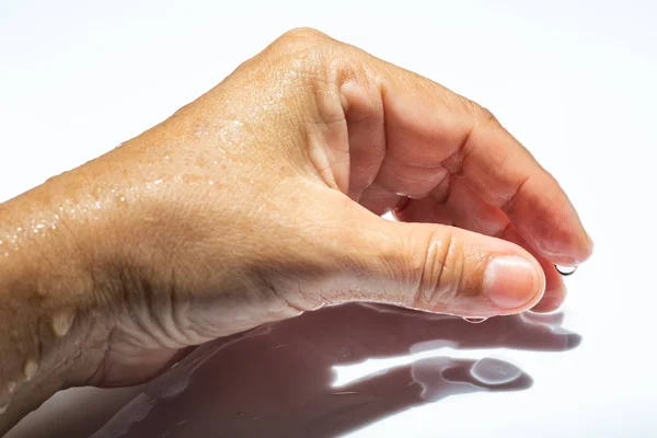 Женская влажная боковая рука с капельками воды на белом акриловом фоне, Крупный план и макроснимок, Выборочный фокус, часть азиатской кожи тела, расслабляющая ванна, концепция здравоохранения — стоковое фото