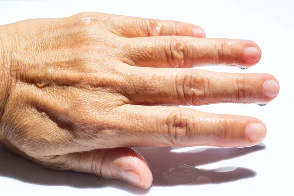 Woman's wet back hand with water drops on white acrylic background, Close up & Macro shot, Selective focus, Asian Body skin part, Relaxing Bath, Healthcare concept — Stock Photo, Image