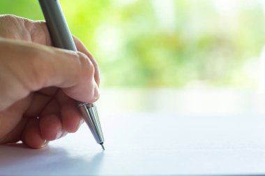 Kadın sol el tutan Gümüş Debriyaj tipi kalem, beyaz kağıt doku arka plan üzerine mektup yazma, defter, kapatmak ve makro Shot, seçici odak, Iletişim, Kırtasiye kavramı