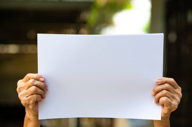 Üst düzey kadının elleri, bokeh arka planda beyaz kağıt boyutu A4 tutarak, seçici odak, Iletişim, iş konsepti