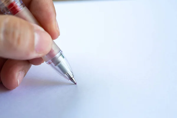Mão esquerda da mulher segurando uma caneta de plástico, escrevendo carta sobre fundo de papel branco, Notebook, Close up & Macro shot, Foco seletivo, Comunicação, Conceito de papelaria — Fotografia de Stock
