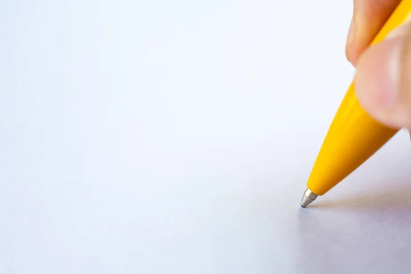 Mão direita da mulher segurando uma caneta amarela, escrevendo carta sobre fundo de papel branco, Notebook, Close up & Macro shot, Foco seletivo, Comunicação, Conceito de papelaria — Fotografia de Stock