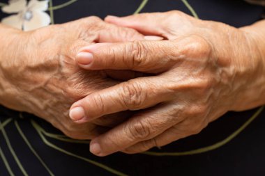 Kıdemli kadın ellerini tutarak ve dua ediyor, Yakın kapat & Makro çekim, Seçici odak, Asya Vücut cilt parçası, Vücut dili hissi, Dini kavram