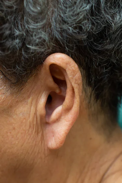 Левое ухо пожилой женщины для прослушивания, Симптом потери слуха, Крупный план и макроснимок, Селективная фокусировка, Азиатская часть тела, Концепция здравоохранения — стоковое фото