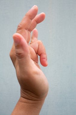 Tetik Parmak kadın tarafının sol elinde yüzük parmağında kilit, Ağrı muzdarip, Mavi-gri renk arka plan, Close up & Macro shot, Office sendromu, Sağlık kavramı