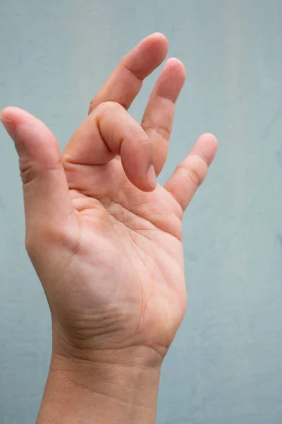 Trigger Finger lock on index finger of woman's side left hand, Suffering from pain, On Blue-grey colour background,  Close up & Macro shot, Office syndrome, Health care concept — Stock Photo, Image