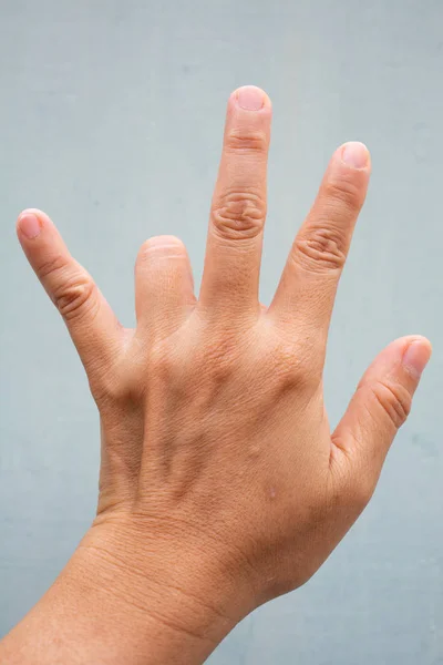 Spust palec blokada na palec serdeczny kobiety z powrotem lewą ręką, cierpiących na ból, na niebiesko-szary kolor tła, zbliżenie & makro strzał, zespół biurowy, koncepcja opieki zdrowotnej — Zdjęcie stockowe