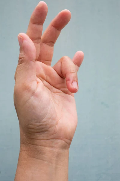 女性の左手の薬指の指ロックをトリガー, 痛みに苦しむ, 青灰色の色の背景に, クローズアップ & マクロショット, オフィス症候群, ヘルスケアコンセプト — ストック写真