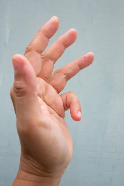 Trigger finger lås på lillfinger av kvinnans sida vänster hand, lider av smärta, på blå-grå färg bakgrund, närbild & Macro Shot, kontors syndrom, hälso-och sjukvård Concept — Stockfoto