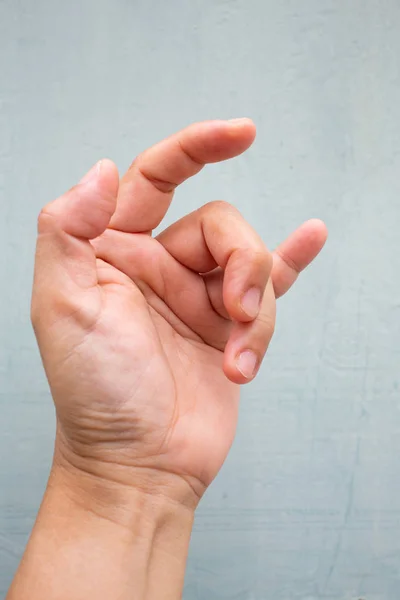 Trigger Finger lock on middle and ring fingers of woman's side left hand, Suffering from pain, On Blue-grey colour background,  Close up & Macro shot, Office syndrome, Health care concept — Stock Photo, Image