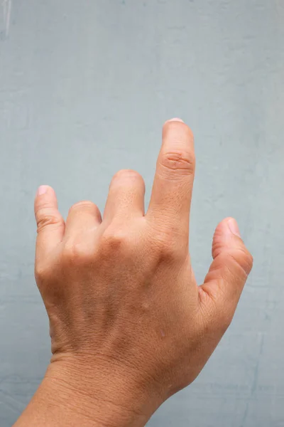 Trigger Finger lock on middle and ring fingers of woman's back left hand, Suffering from pain, On Blue-grey colour background,  Close up & Macro shot, Office syndrome, Health care concept — Stock Photo, Image