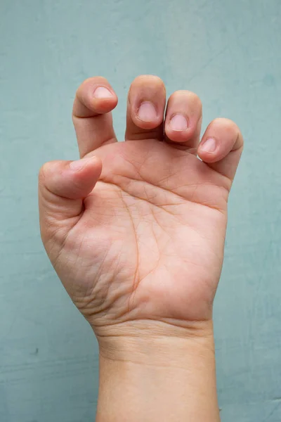 Trigger Finger lock on fingers of woman's front left hand, Suffering from pain, On Blue-grey colour background,  Close up & Macro shot, Office syndrome, Health care concept — Stock Photo, Image