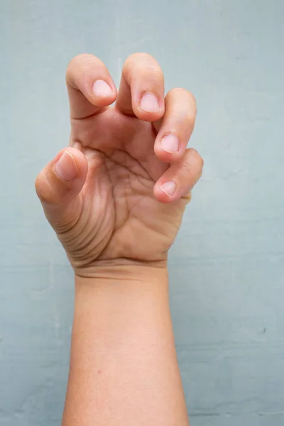 Trigger Finger lock on fingers of woman's front left hand, Suffering from pain, On Blue-grey colour background,  Close up & Macro shot, Office syndrome, Health care concept — Stock Photo, Image