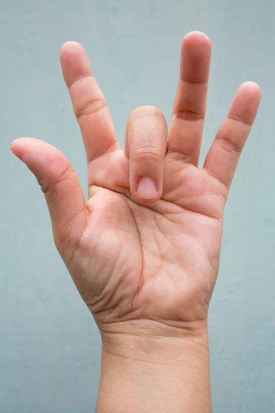 Trigger Finger lock on middle finger of woman's front left hand, Suffering from pain, On Blue-grey colour background, Close up & Macro shot, Office syndrome, Health care concept — Stock Image Trigger Finger lock on middle finger of woman's front left hand, Suffering from pain, On Blue-grey colour background, Close up & Macro shot, Office syndrome, Health care concept Royalty Free Stock Photos