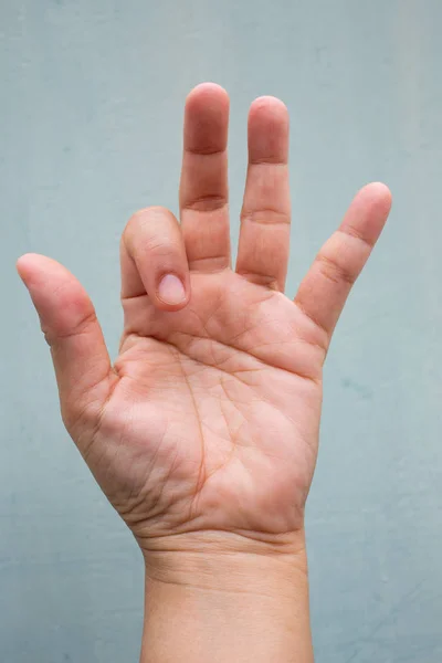 Trigger Finger lock on index finger of woman's front left hand, Suffering from pain, On Blue-grey colour background, Close up & Macro shot, Office syndrome, Health care concept — Stock Image Trigger Finger lock on index finger of woman's front left hand, Suffering from pain, On Blue-grey colour background, Close up & Macro shot, Office syndrome, Health care concept Stock Image