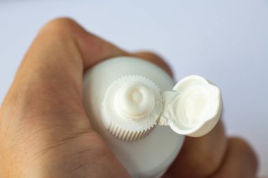 Beyaz arka planda diş macunu sıkan kadın elleri, Close up & Macro shot, Seçici odak, Sağlık konsepti