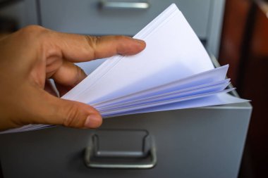 Kadın eli mektup yazmak için beyaz kağıtlar almak, Açık çekmece, Gri gümüş metal renk, Yönetim ve depolama konsepti, closeup & Makro çekim, Seçici odak ile dosya dolabı