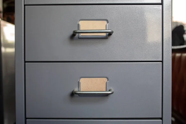 Filing cabinet with closed drawer, 2 brown cards for write letter, Grey silver metal colour, Administration and storage concept, closeup & Macro shot