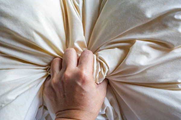 Kvinnans hand klämma elfenben kudde, närbild och makro skott, selektiv fokus, sovrum koncept — Stockfoto