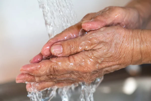 Старшая женщина моет руки, течет и брызгает водой, Закрыть и Макро выстрел, Селективный фокус, Здравоохранение концепции — стоковое фото