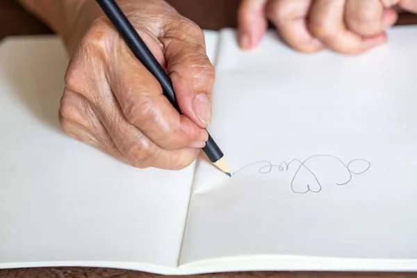 Mujer mayor derecha Escritura a mano "Amor" sobre fondo blanco, Primer plano y plano macro, Enfoque selectivo, Concepto de papelería — Foto de Stock