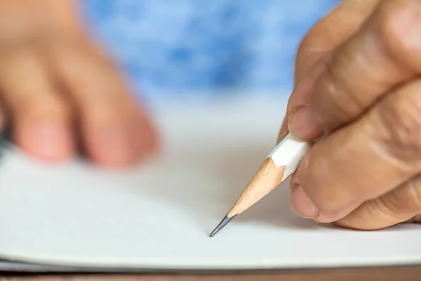 Mujer mayor izquierda Carta de escritura a mano sobre fondo de papel marfil, Cuaderno, Lápiz blanco, Primer plano y plano macro, Enfoque selectivo, Concepto de papelería — Foto de Stock