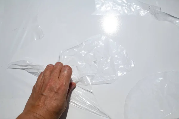 Женщина Левая Рука Скомканный Пластиковый Пакет Обертывания Сером Металлическом Фоне — стоковое фото