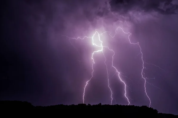 Lightnings over a forest during night thunderstorm — Stock Photo, Image