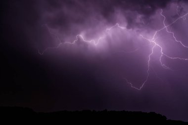 Gece fırtına sırasında orman üzerinde Yıldırımlar