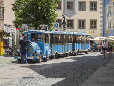 Fssen, Almanya - 03 Temmuz 2017: Mavi şehir tur tren durağında iki römork ve traktör ile. Şehir çeşme. Şövalye yayaları ile sokak.