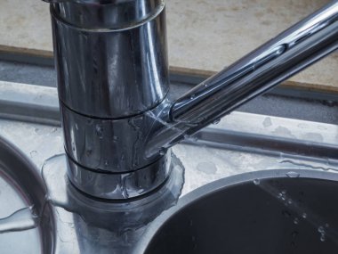 Pencereden bir lavabo üzerinde su jet jeti ile bir sızıntı musluk Close-up.