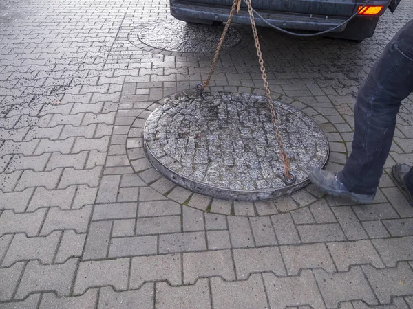 Schwerer Kanaldeckel in der Fußgängerzone angehoben — Stockfoto