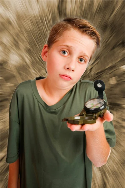 照片上一个12岁的白人男孩 左手边拿着指南针 站在高高的广角3 4的视野中 无助地看着摄像机 面对着一个单色 辐射扭曲的背景 — 图库照片