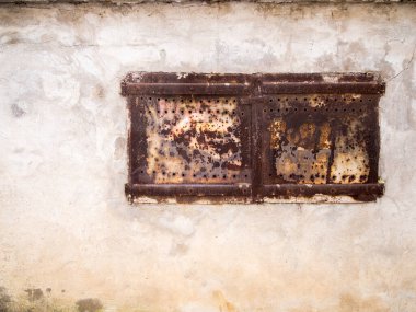 Eski bir duvarda soyulmuş boyayla eski paslı çift kanat..