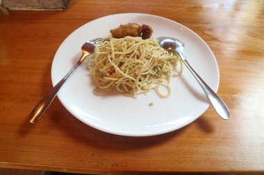 Tahta masada tavuk ve sebzeli spagetti.