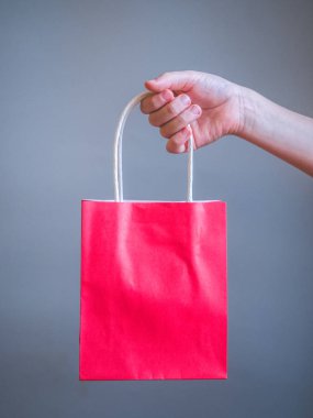Kırmızı çantalı mockup boş şablon gri arka plan üzerinde izole için tutan el