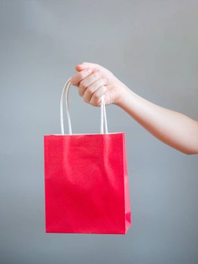 Kırmızı çantalı mockup boş şablon gri arka plan üzerinde izole için tutan el