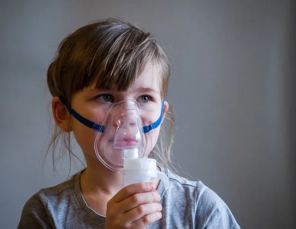 Child making inhalation with mask on his face. Asthma problems concept