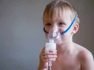 Yüzünde maskeyle enhalasyon yapma çocuk. Astım sorunları kavramı