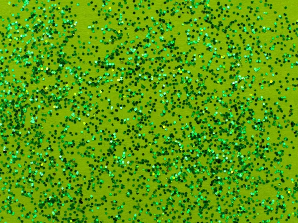 Green glitter sparkle on green background with place for your text