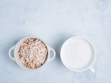 Beyaz bardakta yulaf sütü içeceği ve mutfak bankında tahıl gevreği. Düz yatıyordu. Kopyalama alanı.