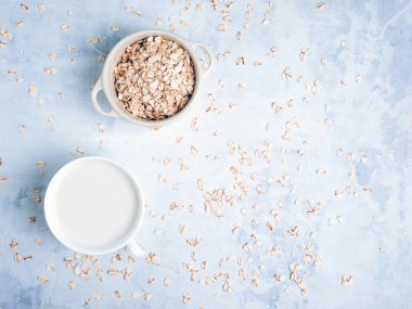 Beyaz bardakta yulaf sütü içeceği ve mutfak bankında tahıl gevreği. Düz yatıyordu. Kopyalama alanı.