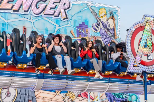 Bir grup insanın bir karnavalda heyecanlı bir gezinti yaptığı yakın çekim. Renkli eğlence eğlencesi neşe, heyecan ve adrenalin duygularını yakalar, enerji ve eğlence dolu canlı bir panayır ortamı yaratır. Nuremberg