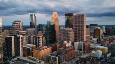 A hyperlapse of downtown Minneapolis, Minnesota by drone with storm clouds at sunset.