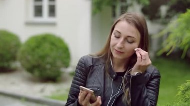 Susuzluğun ortasında mutlu bir kadın müzik dinliyor ve bahçede usulca dans ediyor..